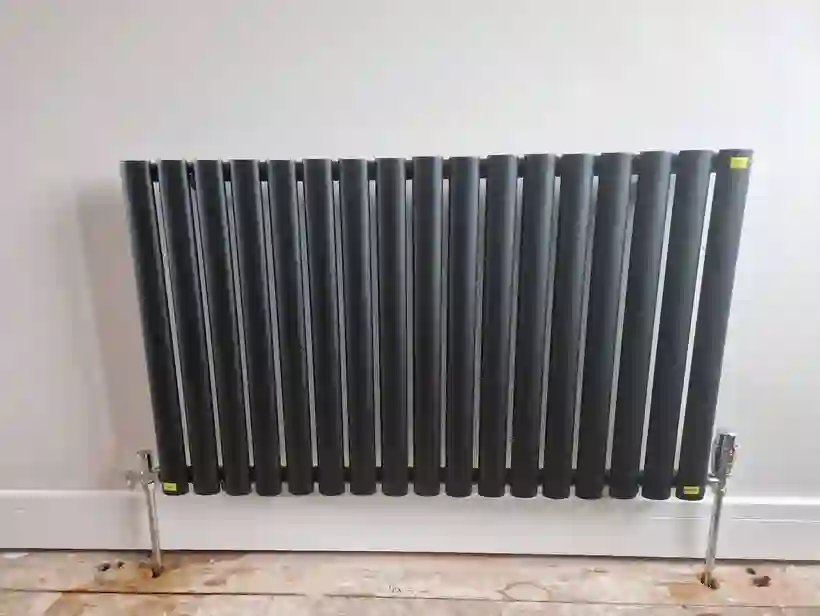 Grey vertical column radiator installed by Marple Flame